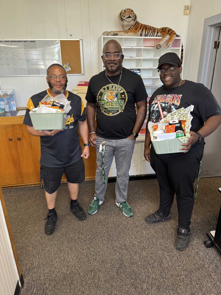 Custodian Appreciation Day - Mr. Pitt and Mr. Roberson holding gift baskets with Principal Howard standing in the middle.