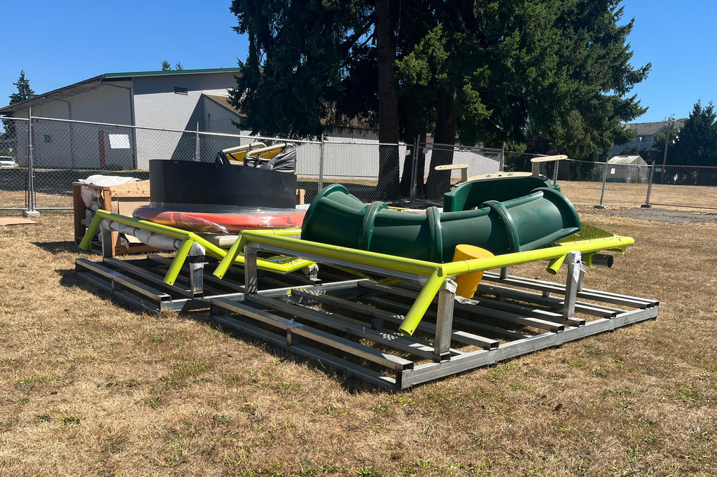 Playground equipment is pictured sitting in the grass outside the new Liberty buildings
