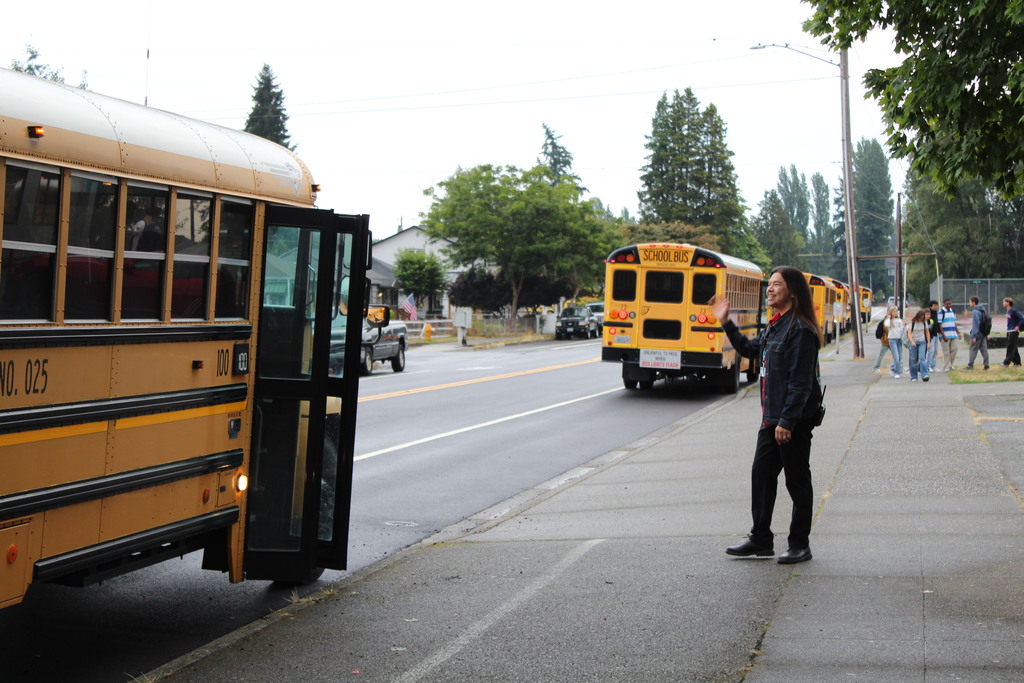 A person waves at a bus 