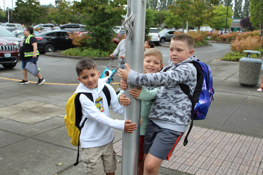 Three kids grab a flagpole