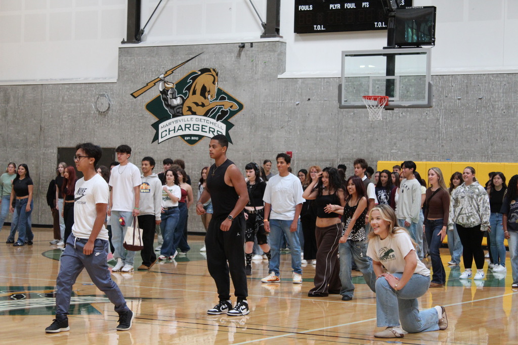 A group of students playing a game are seen smiling in the gym