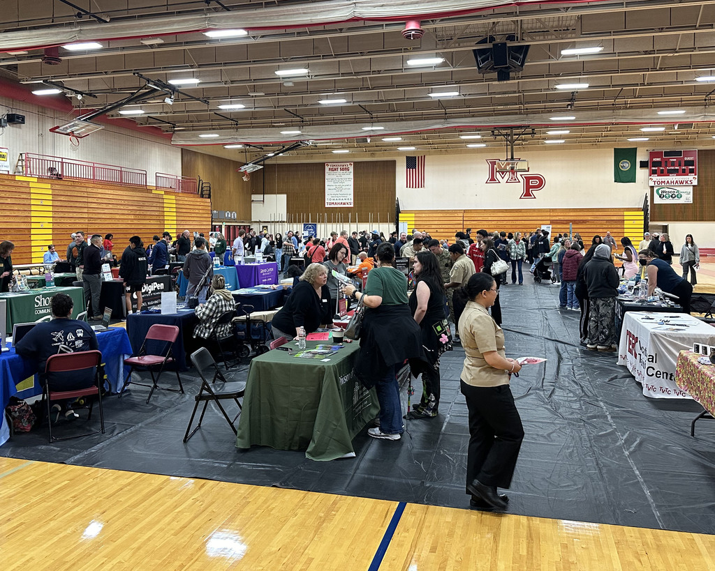 A wide shot of the MP gym with tables set up for the 2024 college and career fair