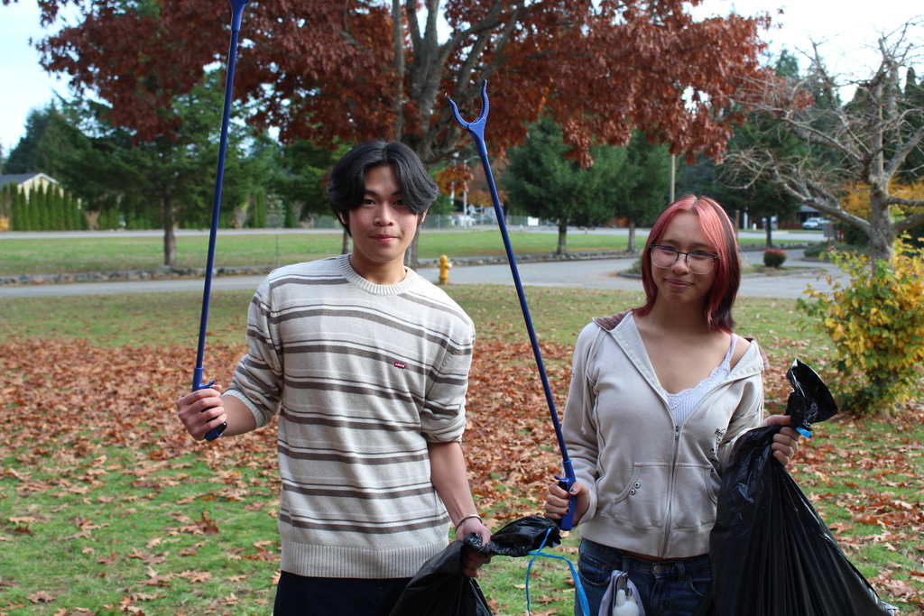 students with trash grabbers