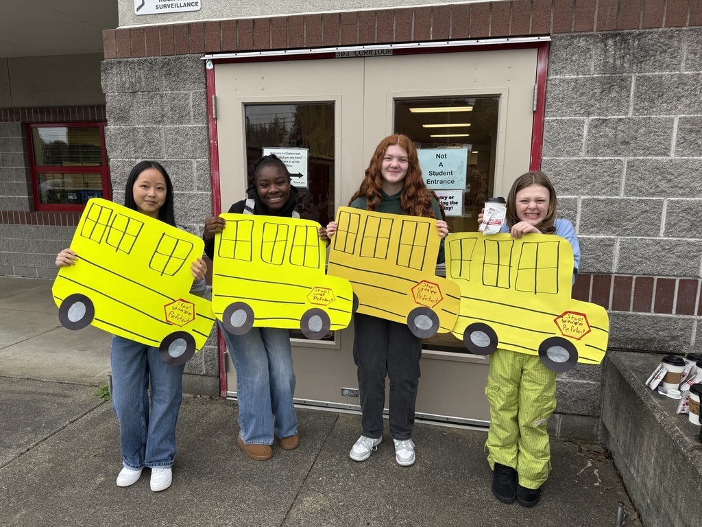 Leadership Students holding bus signs to greet Marysville School District bus drivers for their Appreciation Day.