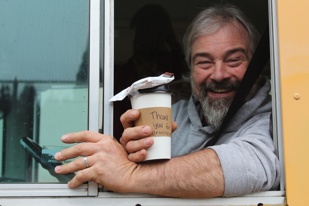 Bus Driver smiling with treat from leadership students