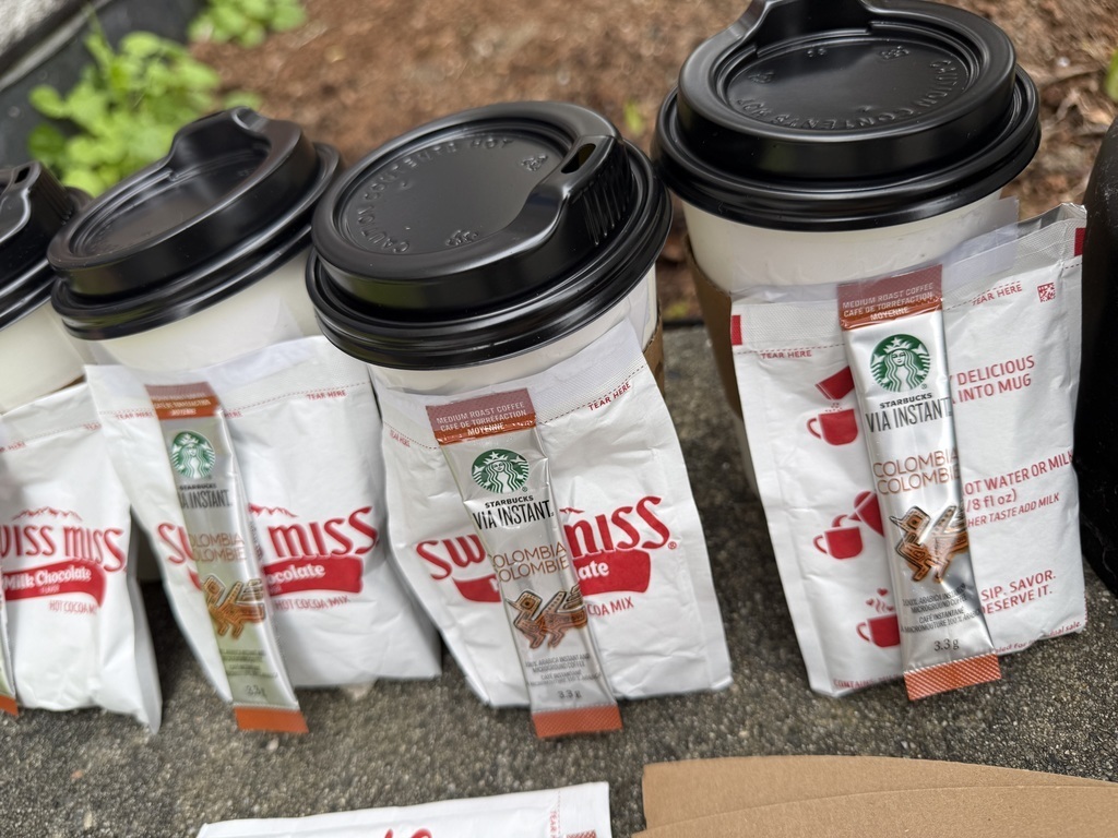 Cups of hot water with a coffee and a hot cocoa packet for the bus drivers.