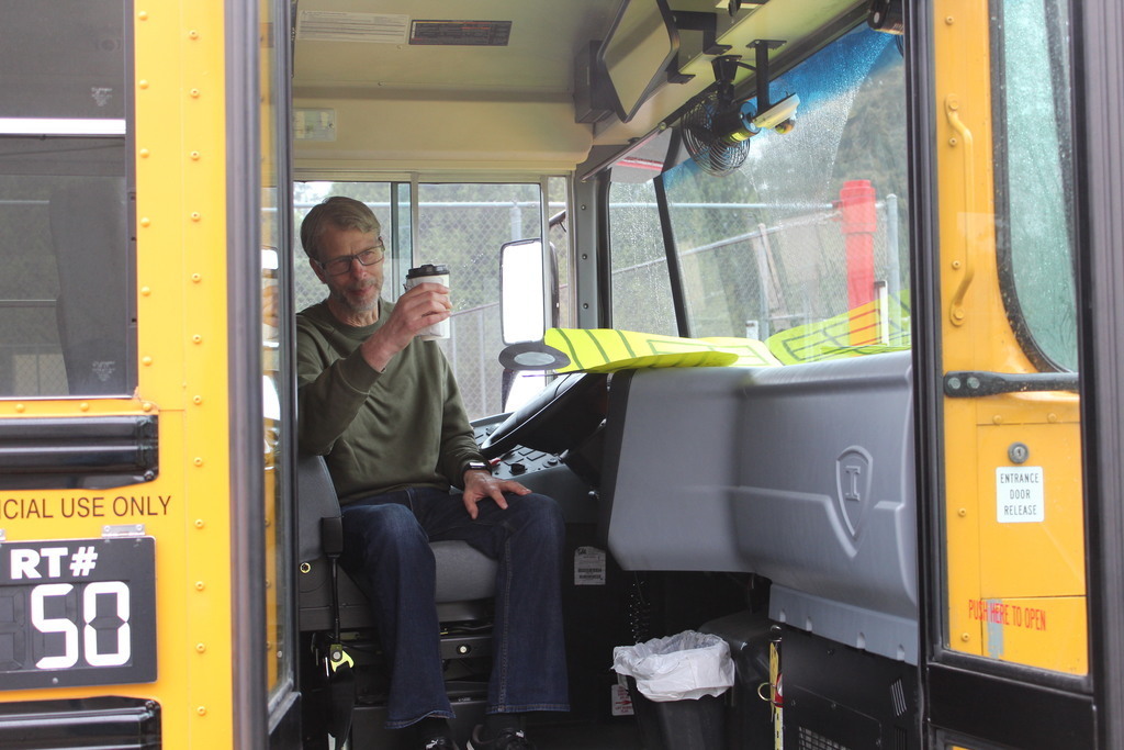 Bus driver cheering with treat from leadership students