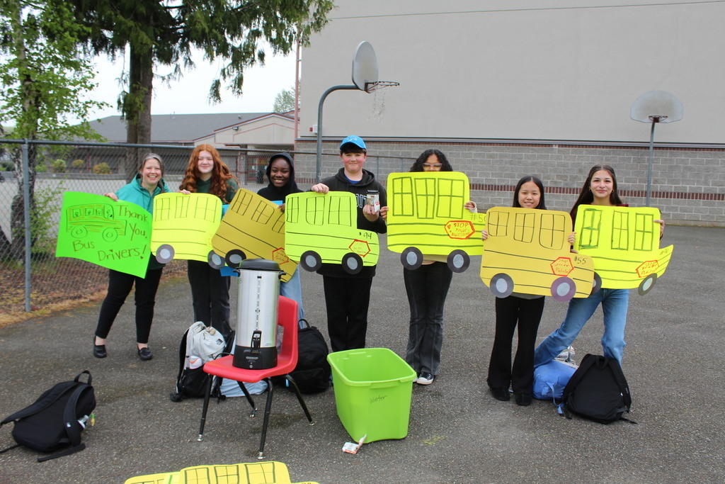 Leadership students and teachers with posters for bus drivers. 