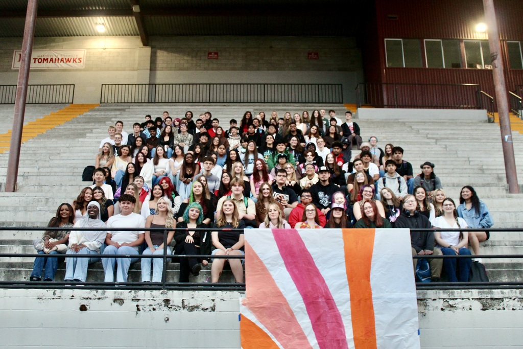 An image of many students sitting in rows of bleachers.
