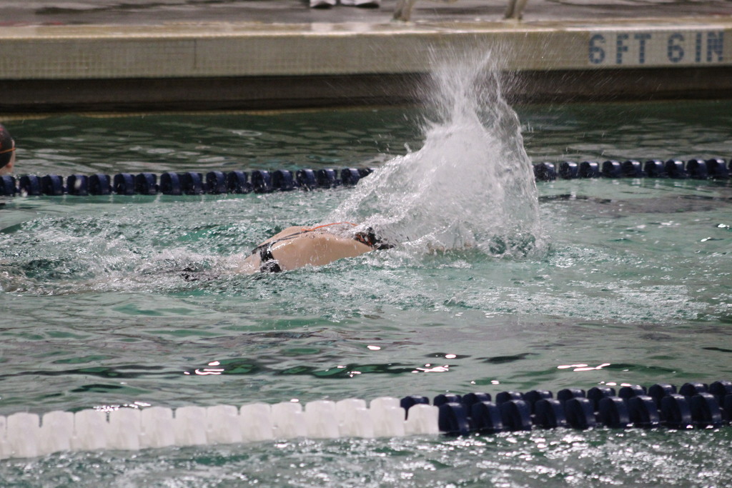 A swimmer is seen in a pool lane with water splashing