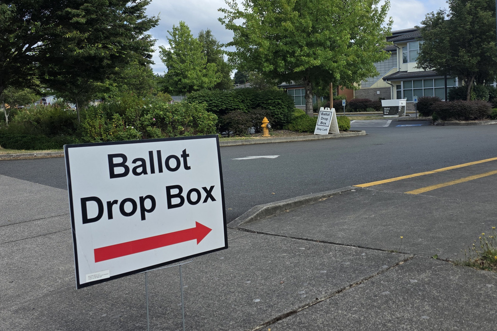 A sign that says "Ballot Drop Box" with a red arrow is seen outside Grove Elementary, with the Ballot Drop Box itself in the far background. 
