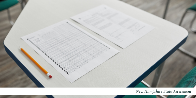 Top down image of a pencil and multiple choice test on a desk. The words "New Hampshire State Assessment" are in the bottom right corner. 