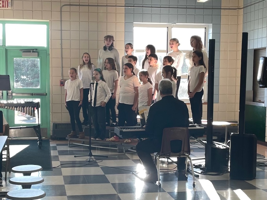 A photo of Boynton Chorus students performing during the Veteran's Day Breakfast in the cafeteria.