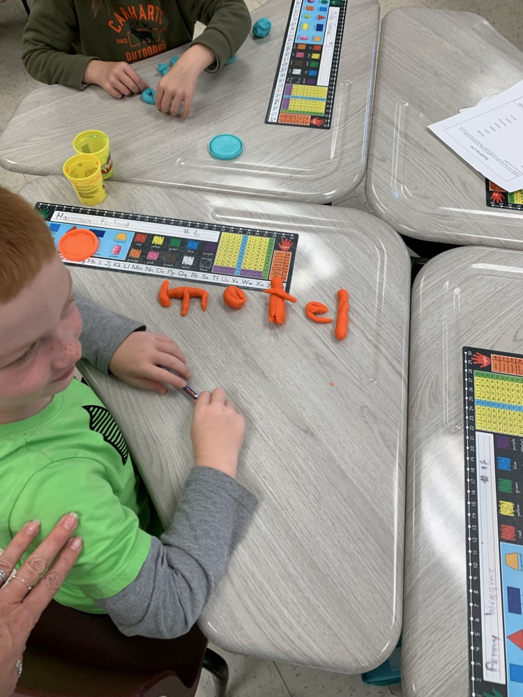kid spelling word with playdoh