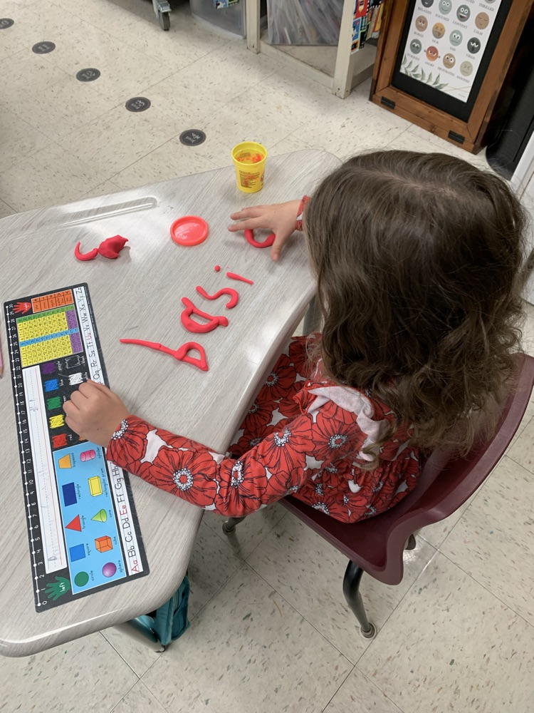kid spelling word with playdoh