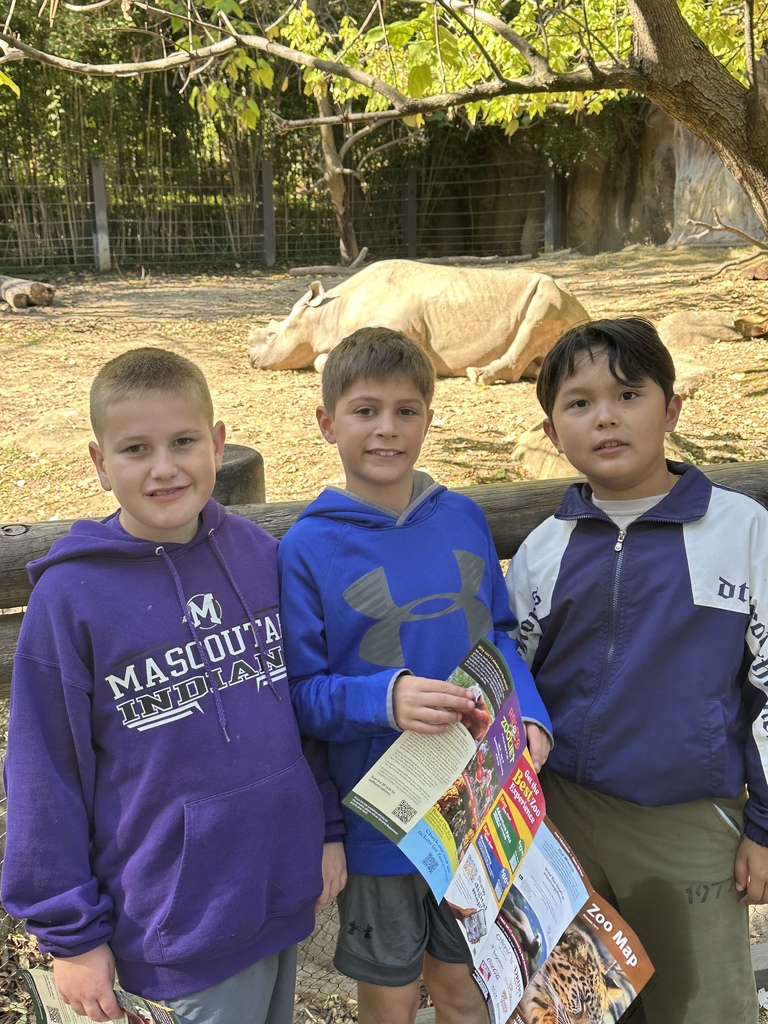 Three kids in front of a rhino 