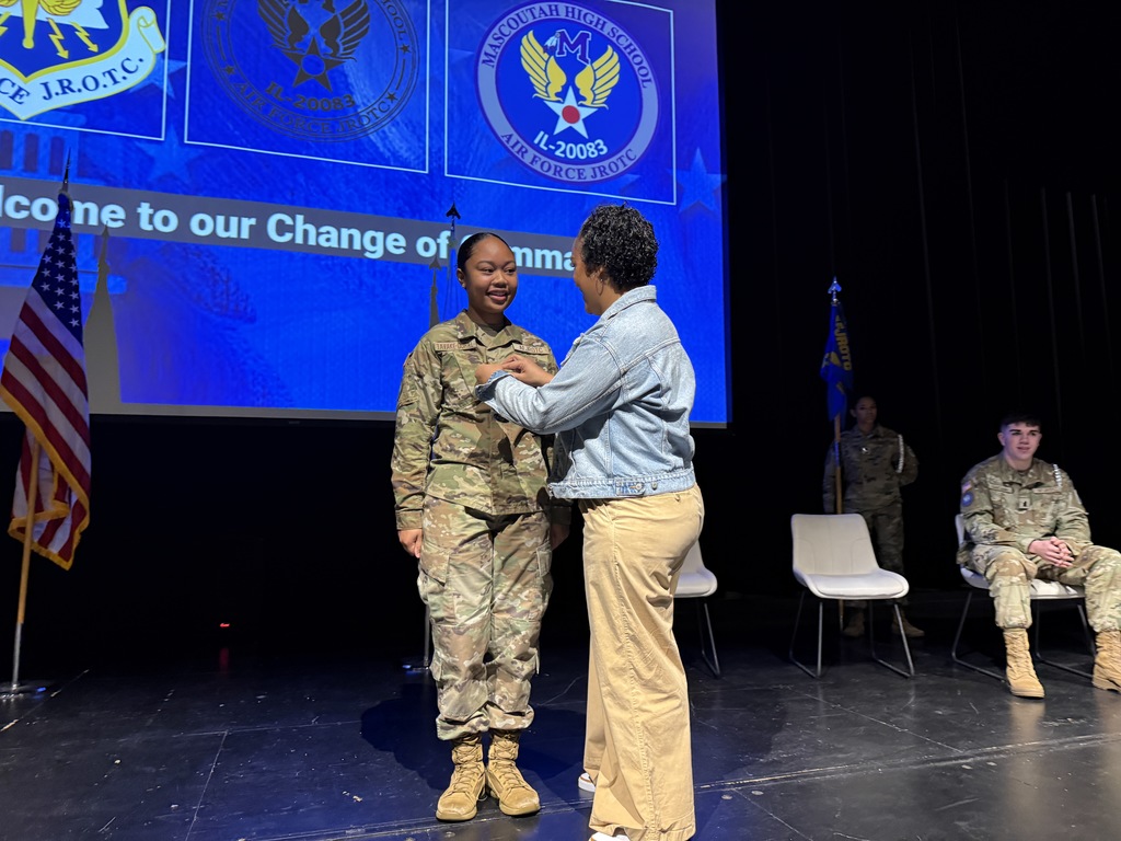 SMSgt Chrissina Dural pinning on her daughter's new rank of Cadet Colonel 