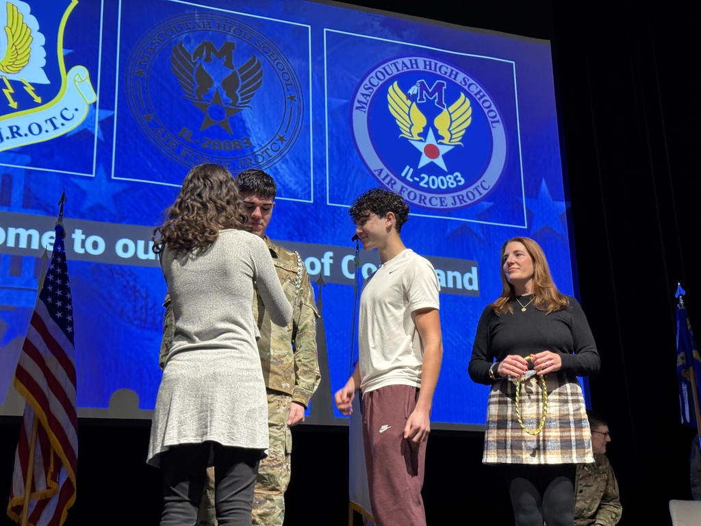 Cadet Sanata's family pinning on his new rank of Cadet Lt Colonel and his mom with the gold shoulder cord