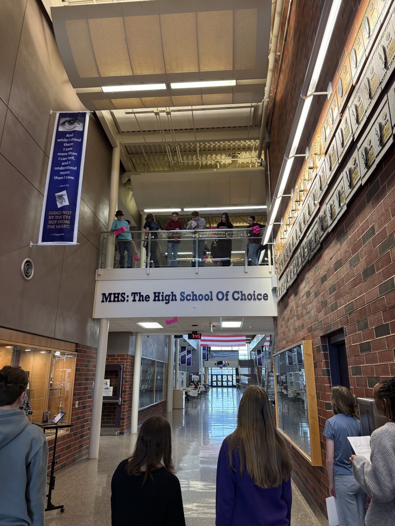 Students dropping paper devices from a balcony.