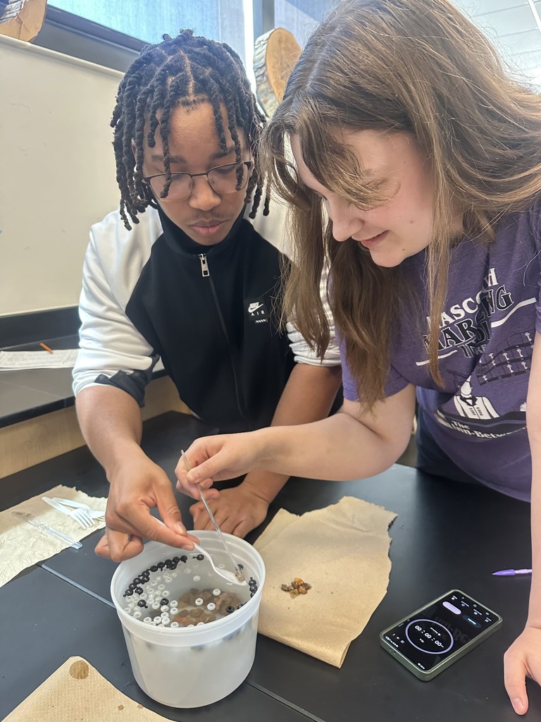 Students diving for beads using spoons.