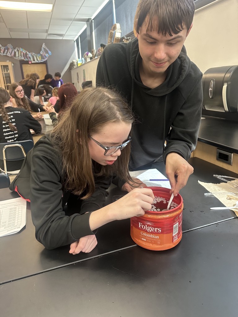 Students diving for beads using spoons.