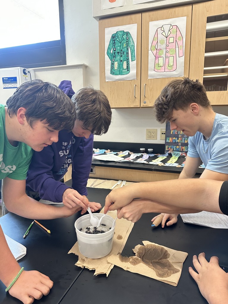 Students diving for beads using spoons.