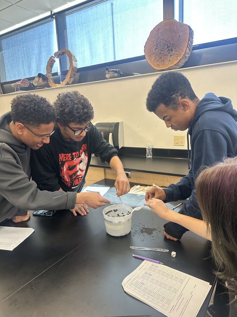 Students diving for beads using spoons.
