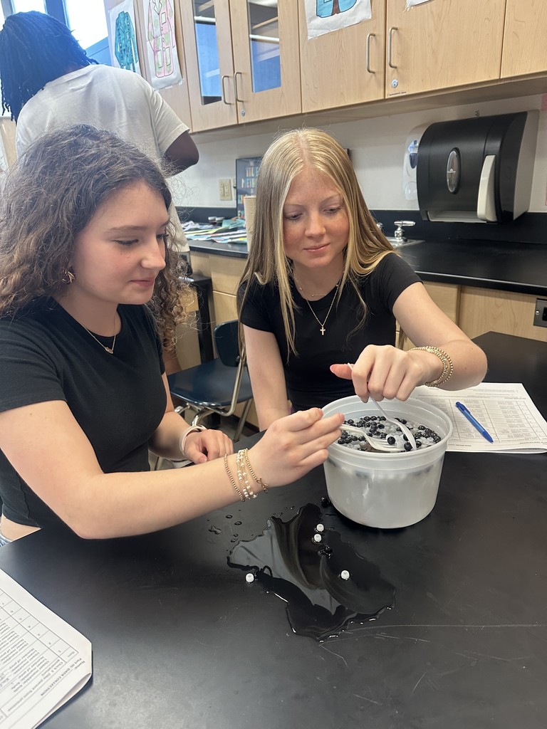 Students diving for beads using spoons.