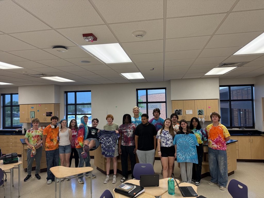 A group of students pose in the tie-dyed clothes they made.