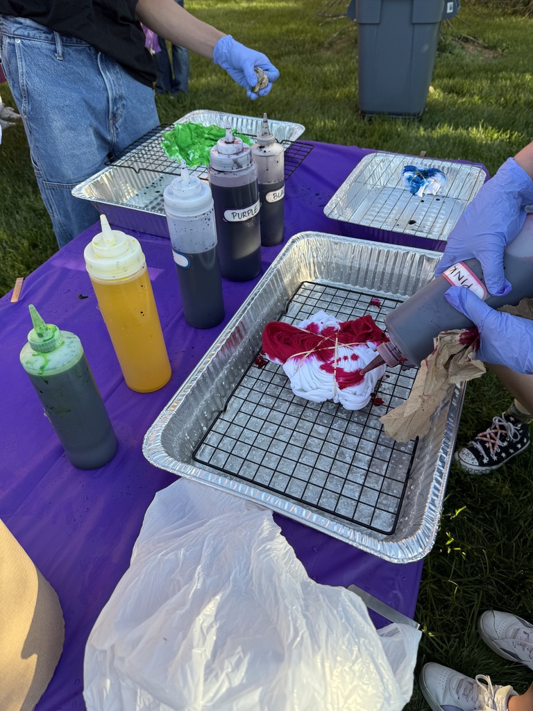 Students apply dye to a folded shirt