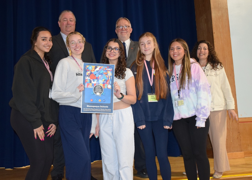 Dr. Brennan and Mr. Green with MHS students displaying the Best Communities for Music Education Award