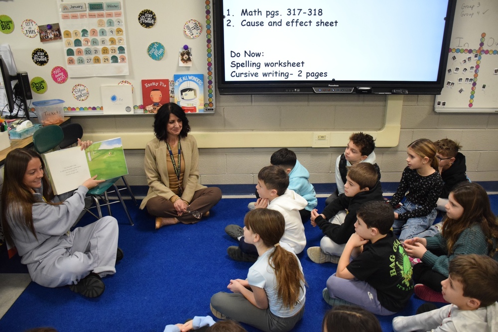 MHS Public speaking student reads to Birch Lane students alosn with Ms. Farrell, CA for ELA and Library