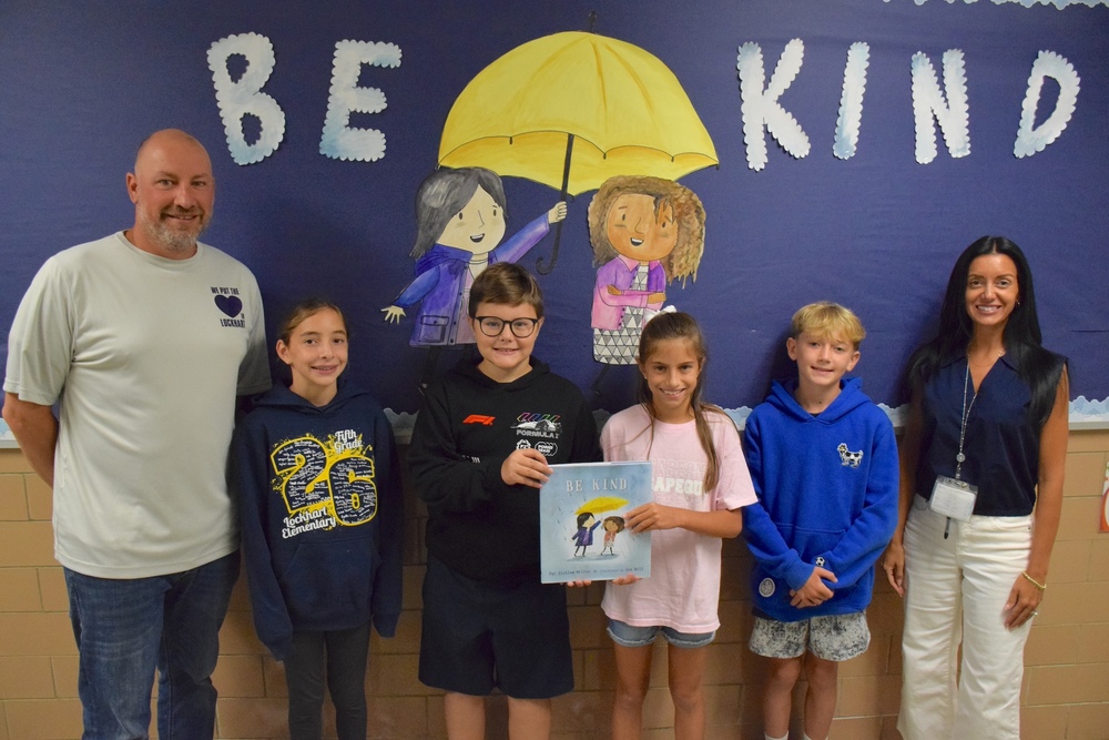 Mr. DeLuca and Mrs. Vecchione with students displaying Kindness book lockhart students are reading