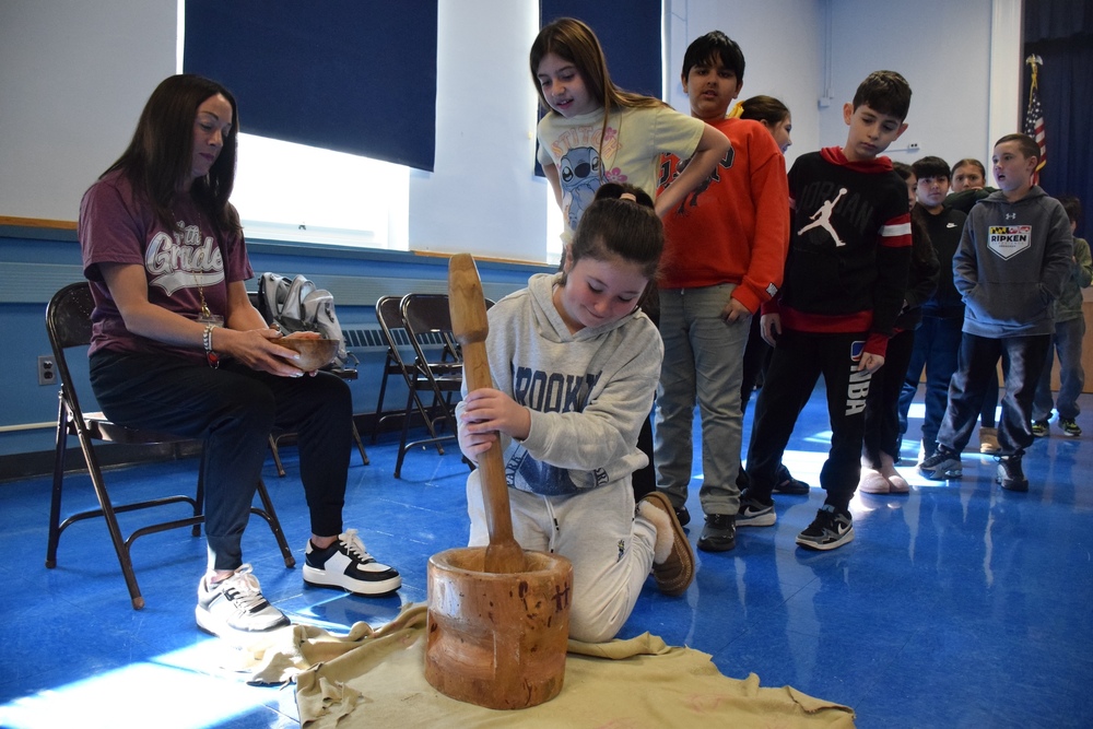 fairfiel students watching classmate churning butter at the American Indian Journeys event