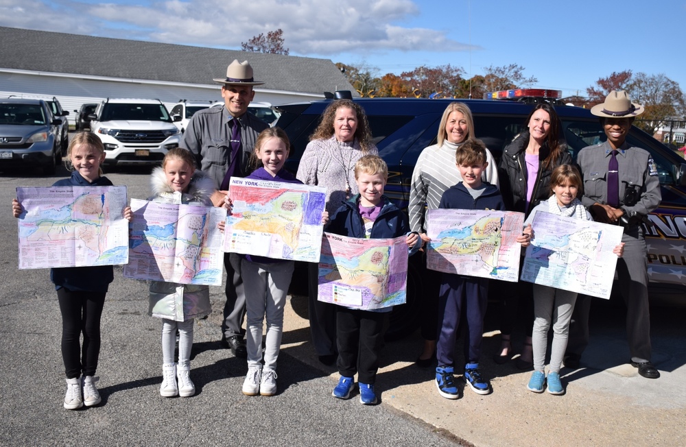 Lockhart students holding maps of new york during NYS Trooper visit