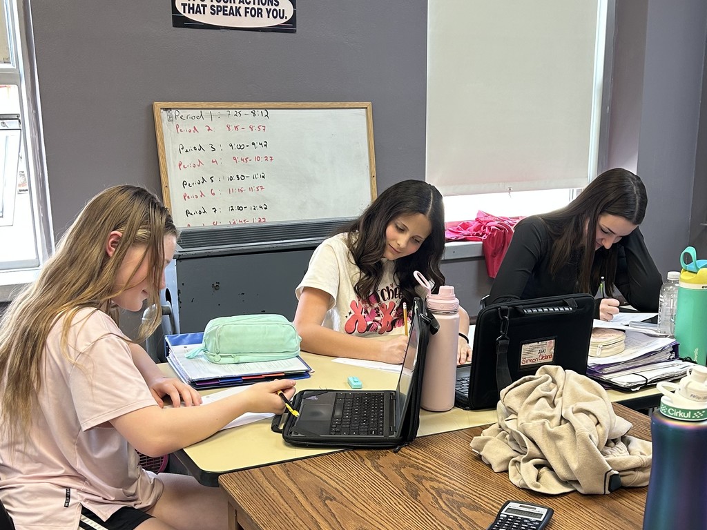 Students work on math assignments involving equations, volume, and probability in a classroom setting.