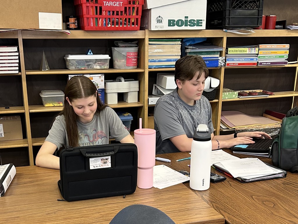 Students work on math assignments involving equations, volume, and probability in a classroom setting.