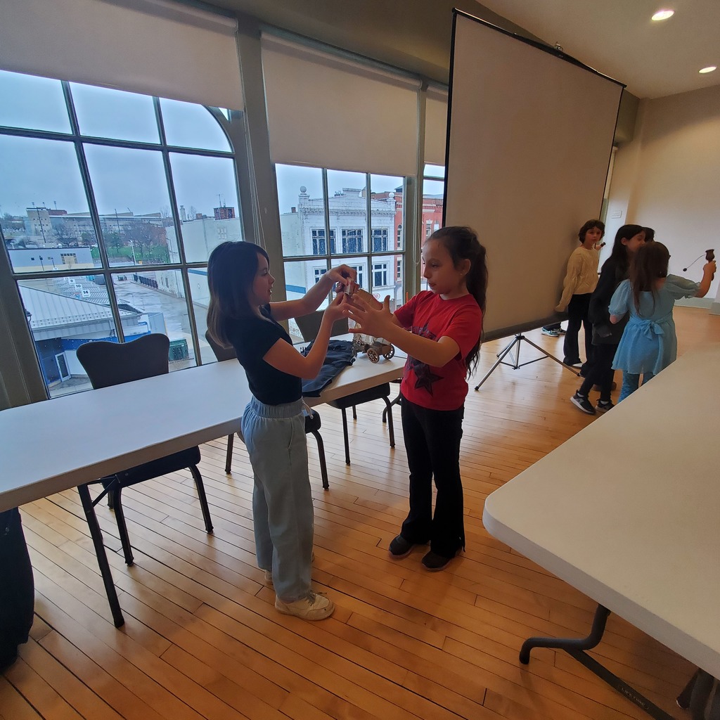 Group of elementary students touring museum exhibits and viewing artwork during a school field trip.