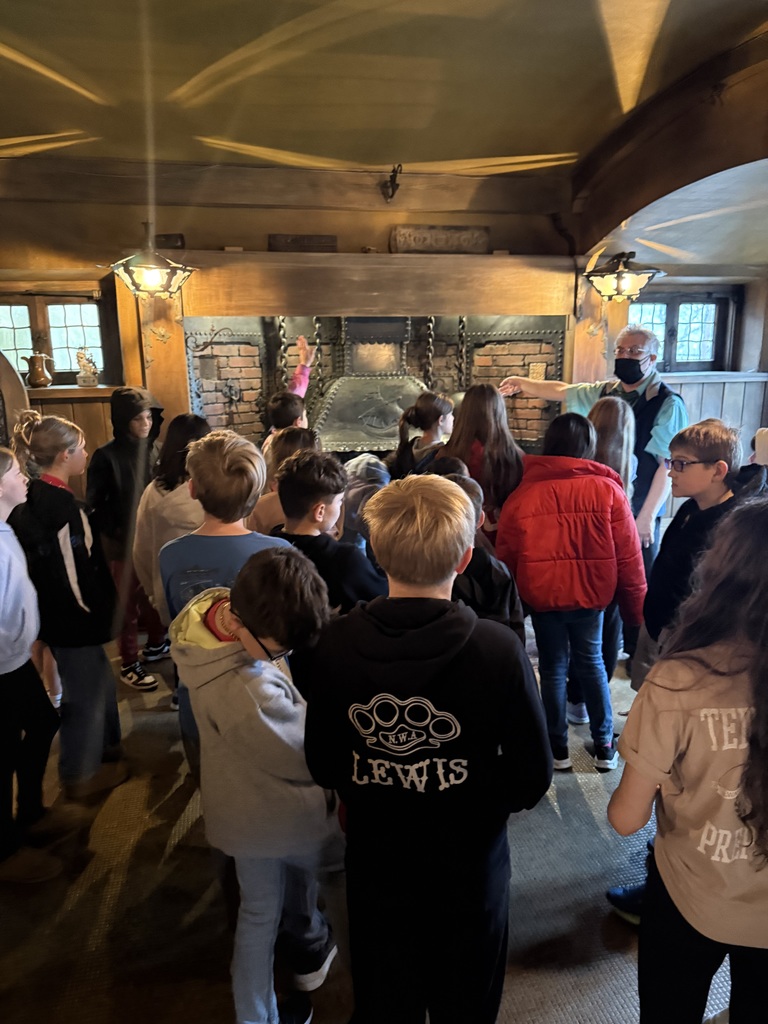 Group of elementary students touring museum exhibits and viewing artwork during a school field trip.