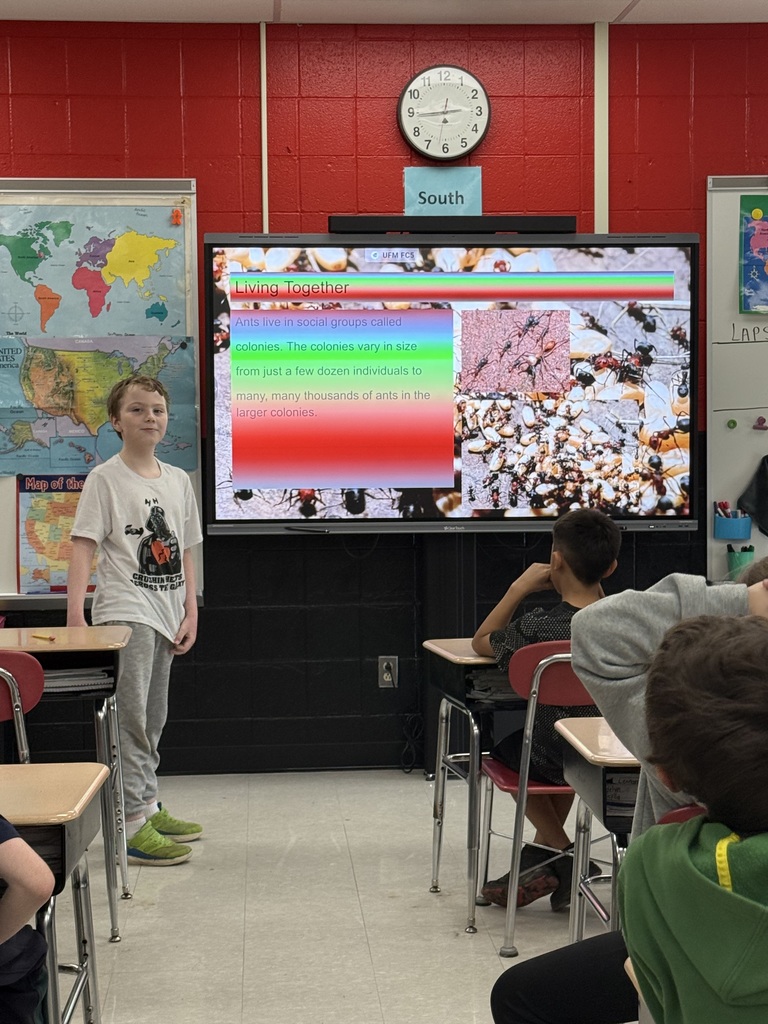 Elementary students presenting a slideshow about insect life cycles