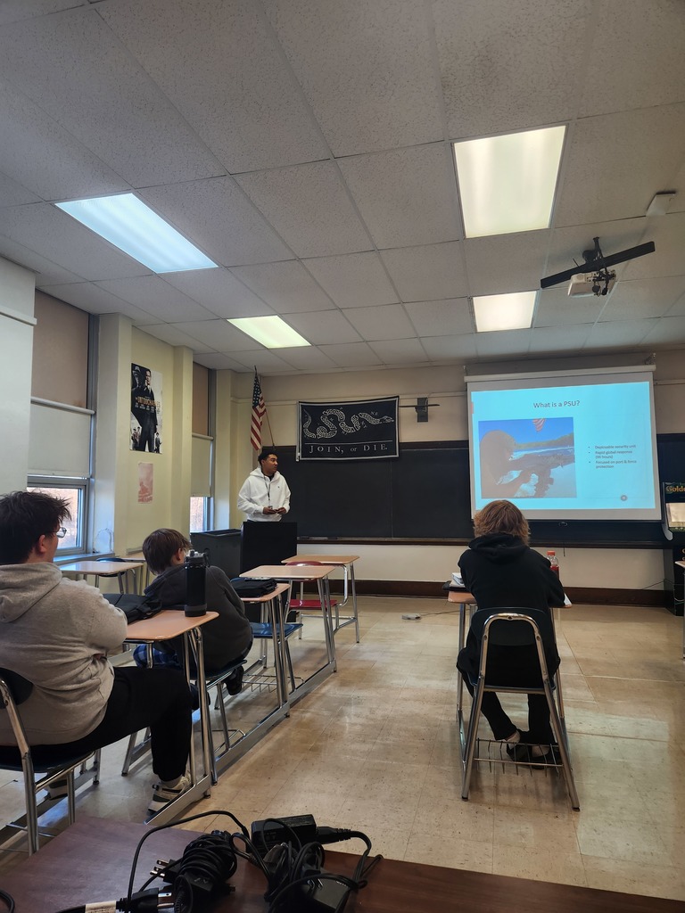 Law enforcement professionals speaking to high school students in a classroom