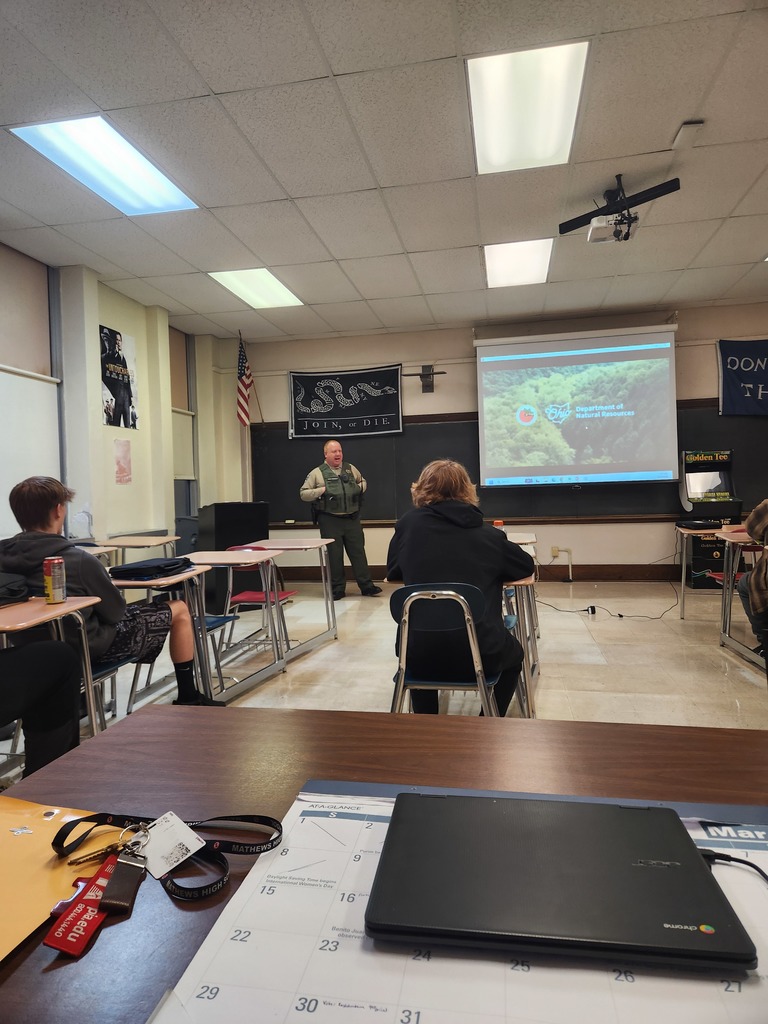 Law enforcement professionals speaking to high school students in a classroom