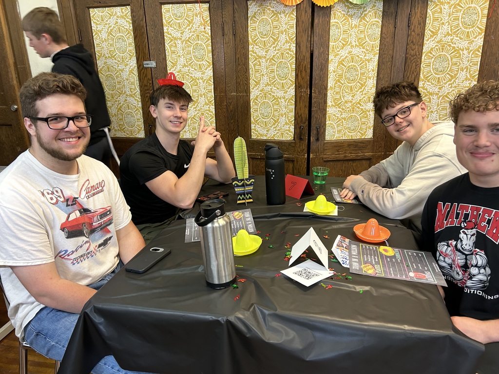 Spanish II students serving authentic Hispanic food to classmates and staff during a classroom restaurant project with menus and dine-in dining tables.