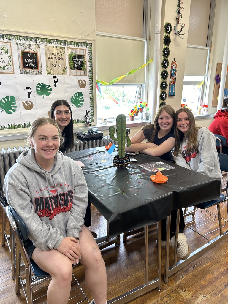 Spanish II students serving authentic Hispanic food to classmates and staff during a classroom restaurant project with menus and dine-in dining tables.