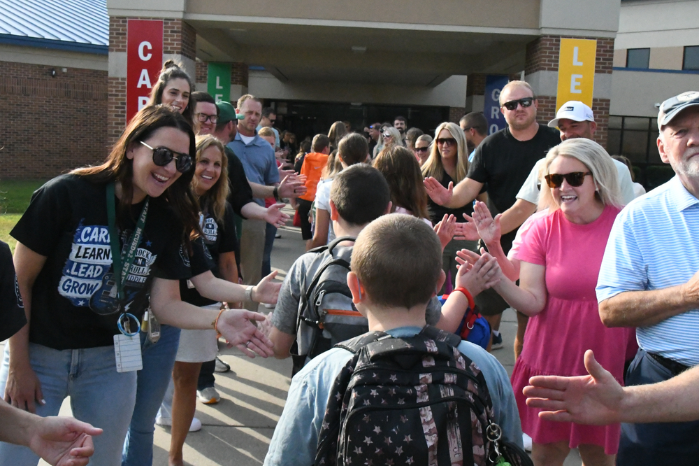 Riddle Elementary Parade. Students walking through the middle into school getting high-fived from community members