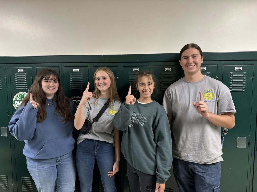 Four MHS students who took first place in the Section 20 Food Science competition. They are holding up the number sign with their hands as they stand in front of lockers.