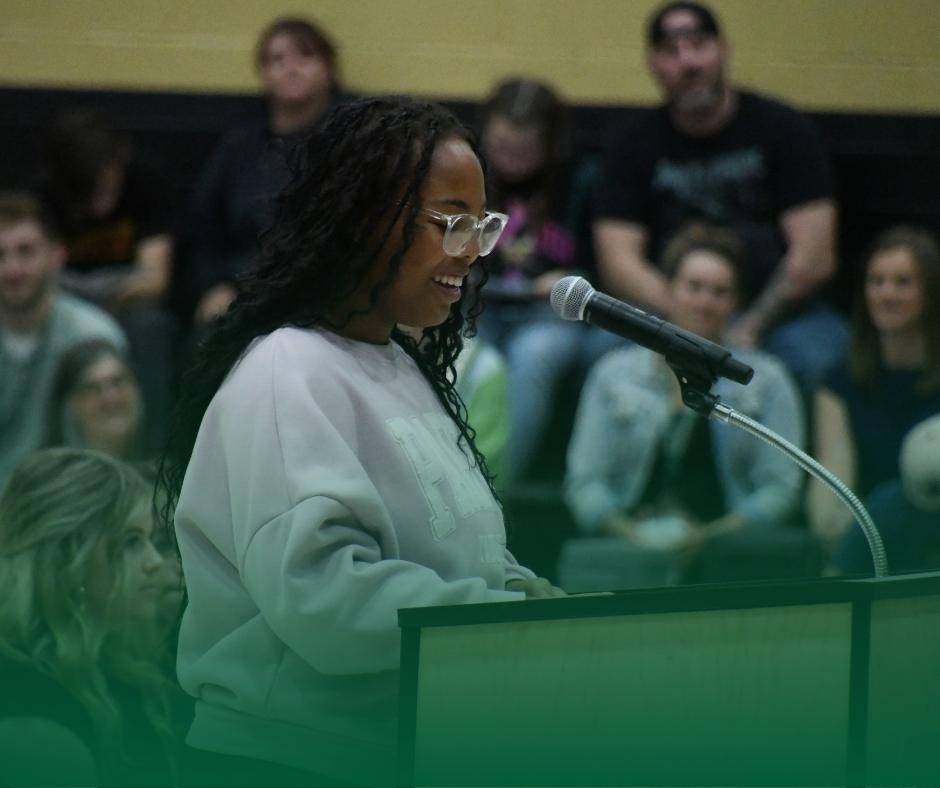 Photo of a MHS student speaking at a podium in front of a crowd