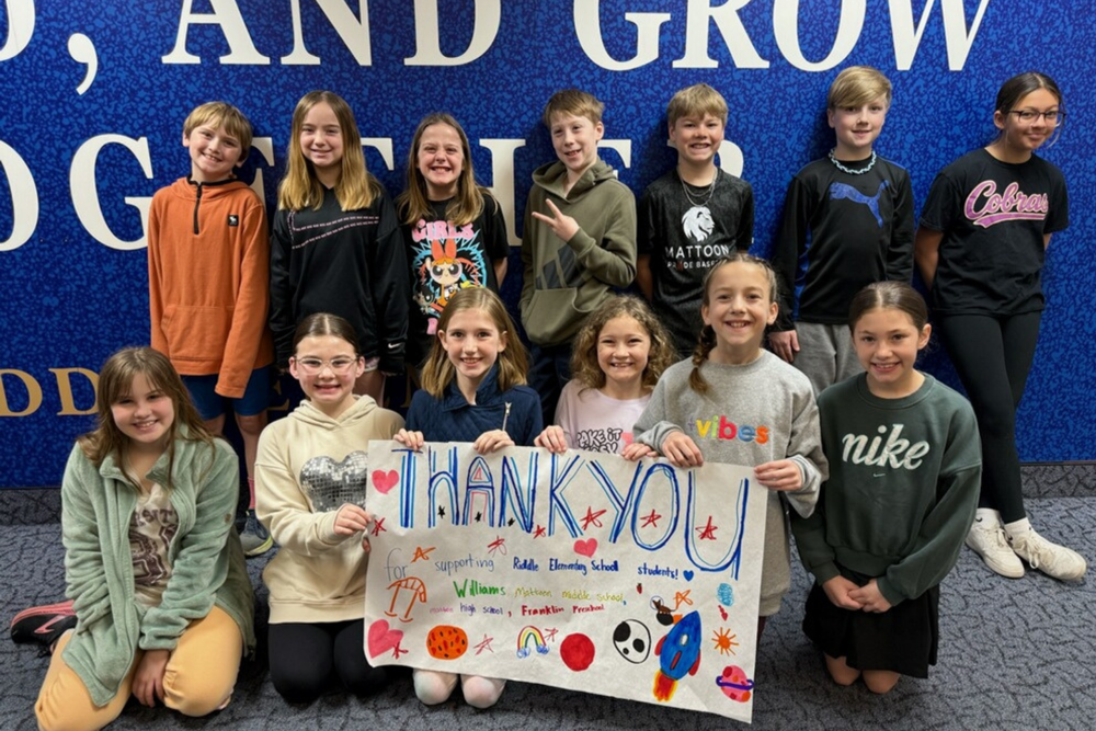 RIDDLE STUDENTS HOLDING UP A THANK YOU CARD