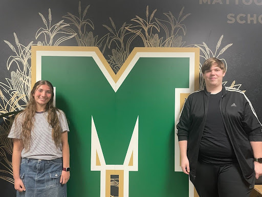 Two MHS students standing next to a wall that had a MCUSD2 logo on it. They are the Rotary Students of the Month