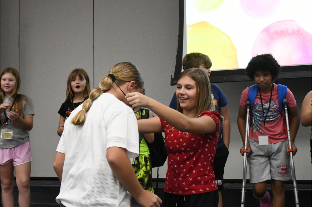 student putting a lanyard on another for leadership roles